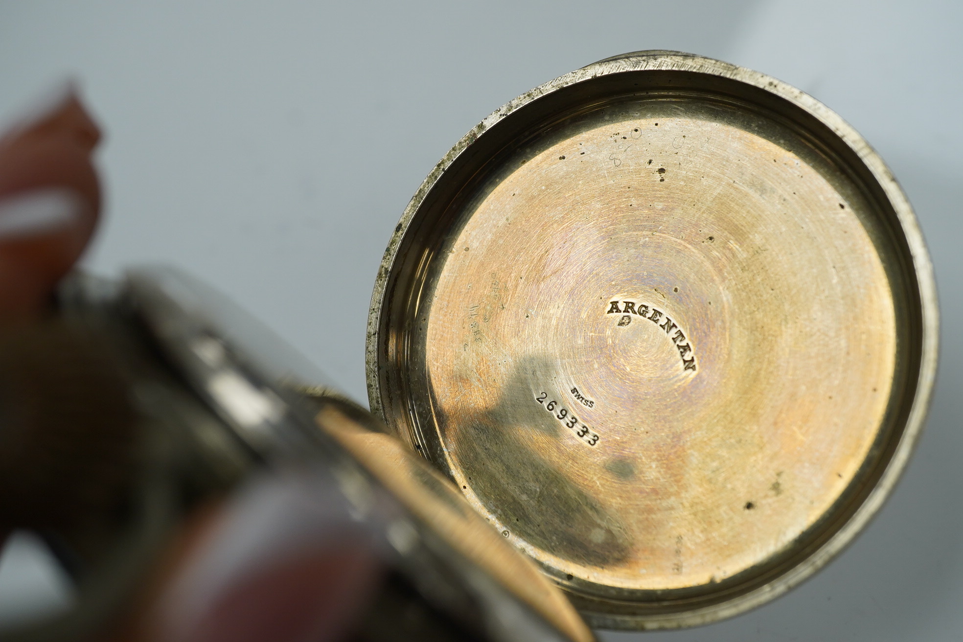 An Edwardian repousse silver mounted travelling watch case, maker W.?, Chester, 1902, 11.1cm, containing a nickel cased pocket watch. Condition - poor to fair